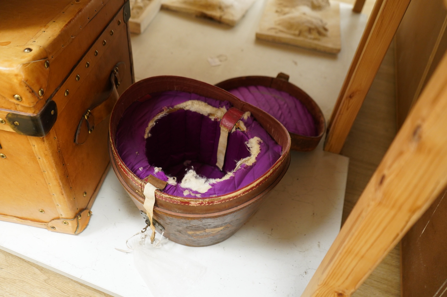 A leather trunk and top hat in box